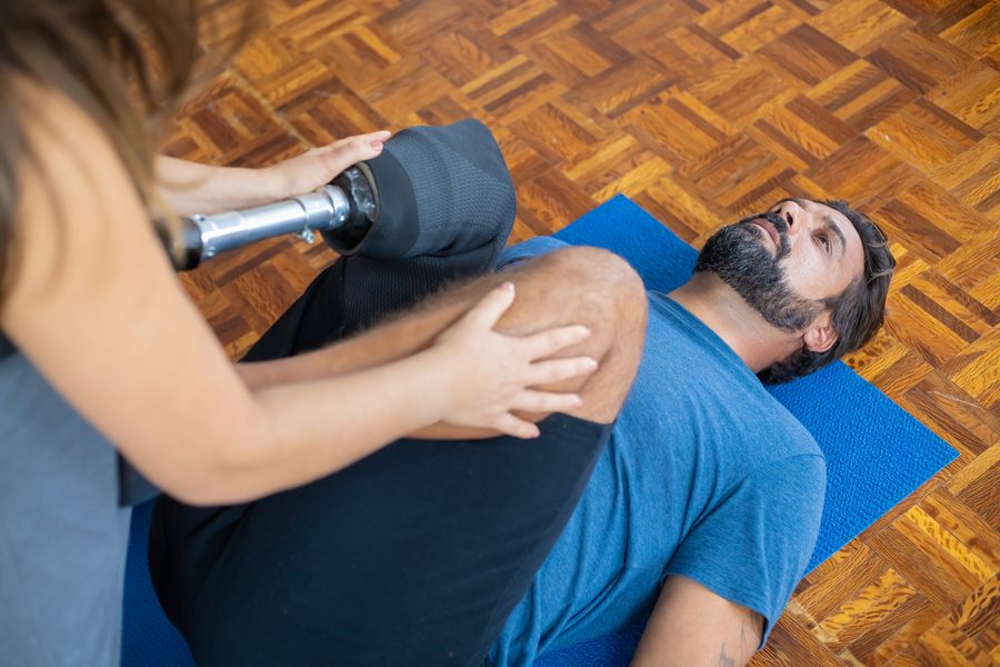 A patient doing guided knee rehabilitation exercises with a physiotherapist
